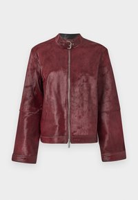 Veste en cuir bordeaux avec un col, une fermeture éclair et des manches larges ; elle présente une texture douce et un design minimaliste.