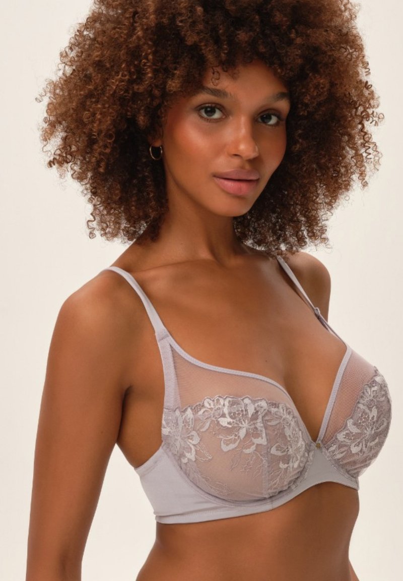 Jasnoszara bielizna z koronkowym wzorem kwiatowym, gładka tkanina, dekolt w serek, regulowane ramiączka i zaokrąglony kształt dla wsparcia.