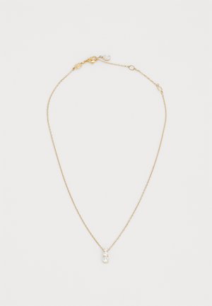 Kuldne kaelakee, millel on väike, selge vääriskivi ripats. Ahel on peen ja kerge keerduva tekstuuriga ning sellel on krabisulgedega kinnitus.