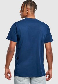 Mørkeblå bomulds t-shirt med rund hals, korte ærmer og en glat overflade, set fra ryggen, der viser en afslappet pasform.