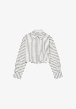 Camicetta bianca cropped con strisce verticali blu e oro, dotata di colletto, maniche lunghe e dettagli di orlo sfilacciato.