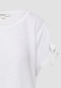 Witte t-shirt met korte mouwen, een ronde halslijn, een zachte textuur en trekkoordaccenten op de mouwen. Lichtgewicht stof, casual ontwerp.