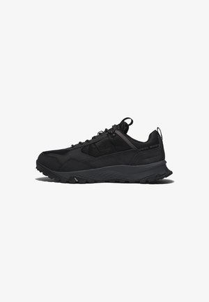 Chaussure de sport noire avec semelle robuste, dessus en mesh et synthétique, design à lacets et languettes sur la languette et le talon, présentée sur fond blanc.