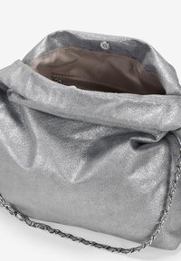 Bolso de mano metálico plateado con textura arrugada, correa de cadena y diseño suave y flexible. El interior cuenta con un bolsillo con cremallera.