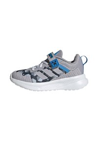 Gray athletic shoe with mesh upper, blue accents, and a textured sole. Features Velcro strap and geometric pattern on the toe.