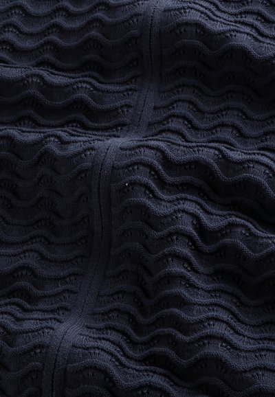 Marinblå stof med et tekstureret, bølget mønster med forhøjede riller og dale, fremstillet af strikket materiale, der ser blødt og fleksibelt ud.