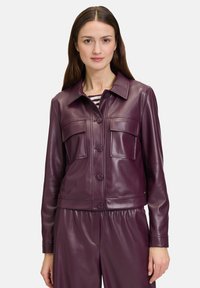 Bordowa skórzana kurtka z kołnierzykiem, dwoma kieszeniami na piersi i zapięciem na guziki. Gładka faktura i skrócony krój doskonale współgrają z pasującymi spodniami.