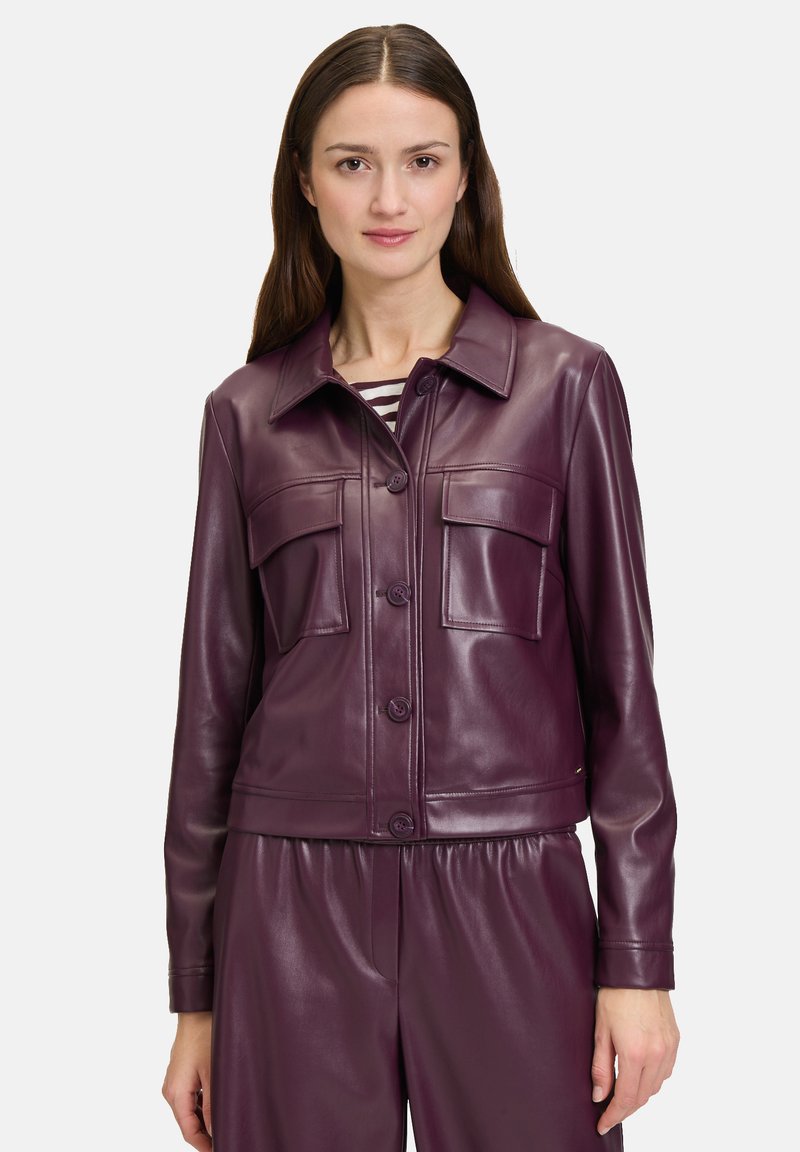 Bordowa skórzana kurtka z kołnierzykiem, dwoma kieszeniami na piersi i zapięciem na guziki. Gładka faktura i skrócony krój doskonale współgrają z pasującymi spodniami.