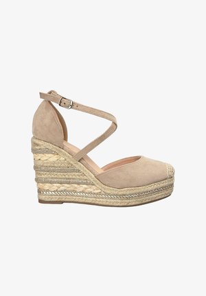Sandali con zeppa in suede beige, con punta arrotondata, cinturino alla caviglia a incrocio e piattaforma in giuta intrecciata con accenti metallici.