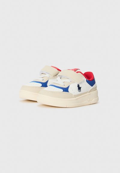 Zapatillas blancas y azules con acentos beige y un interior rojo; cuentan con correas de gancho y bucle y una suela de goma texturizada.