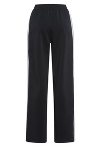 Black athletic pants with an elastic waistband, featuring gray side stripes, wide-leg design, and a smooth, soft texture.