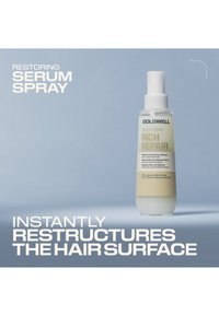 Goldwell Rich Repair Restoring Serum Spray fles op een blauwe achtergrond met tekst over directe herstructurering van het haaroppervlak.