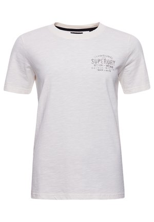 Biała koszulka z krótkim rękawem i okrągłym dekoltem z małym, wyblakłym czarnym napisem „Superdry Work Wear” na lewej piersi.