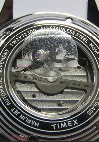Retro orologio Timex sul retro, in acciaio inossidabile, con un adesivo protettivo trasparente, che mostra dettagli incisi: "Miyota Giappone", "21 Gioielli" e marchio CE.