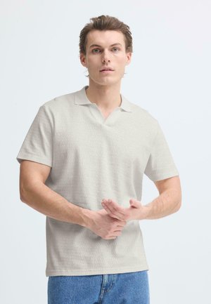 Hellgraues kurzärmeliges Poloshirt mit einem strukturierten Wellenmuster und V-Ausschnitt, kombiniert mit Jeans. Einfaches und strukturiertes Design.