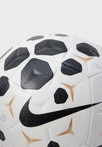 Fehér és fekete Nike focilabda, texturált hatszögletű mintákkal és arany csillagforma díszítéssel, közeli nézet.