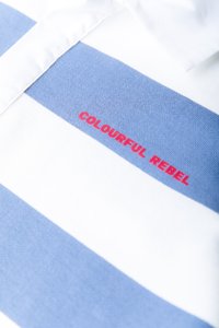 Πόλο μπλουζάκι με κοντά μανίκια, με μπλε και άσπρες ρίγες. Το ύφασμα είναι απαλό, με κεντημένο το "COLOURFUL REBEL" με κόκκινη κλωστή στο μπροστινό μέρος.