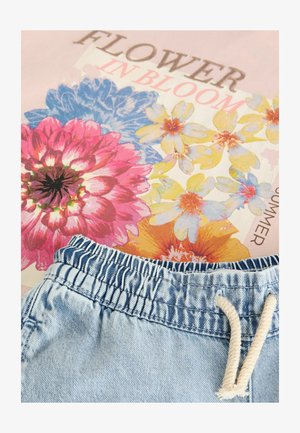 Traperice kratke hlače s elastičnim pojasom, koje imaju vezicu, preko cvjetnog materijala u ružičastim, plavim i narančastim nijansama.