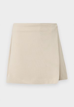 Jupe portefeuille beige asymétrique avec un design épuré et simple, et une texture de tissu lisse.