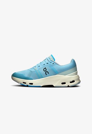 Chaussure de sport bleu clair avec une tige en maille, un col rembourré, des accents gris contrastants et une épaisse semelle blanche dotée d'ouvertures d'aération.