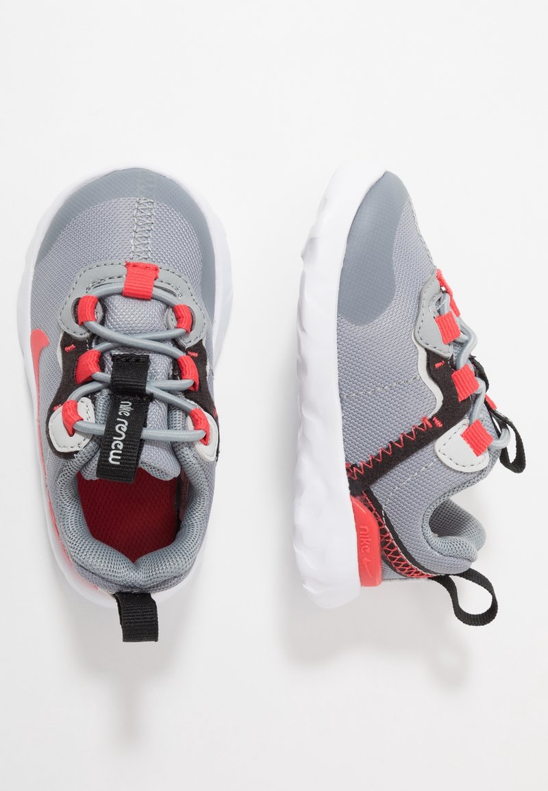 Paire de baskets gris et rouge pour tout-petit avec semelles blanches, lacets élastiques et languettes noires sur fond blanc.