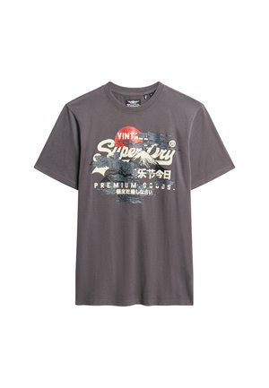 Grå bomulds t-shirt med grafisk print af bjerge og sol, med "Superdry" tekst i hvid og sort. Korte ærmer og rund hals.