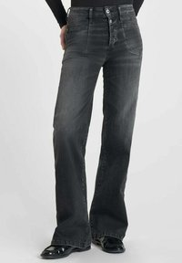 Pantalones vaqueros negros acampanados de denim con un acabado descolorido, que cuentan con una cintura alta, diseño de cinco bolsillos y dos botones en la parte delantera.