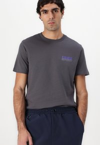 Gray cotton t-shirt with short sleeves and a crew neckline, featuring a purple graphic text "1986 SPORT" on the left chest area.