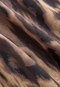 Tejido texturizado con un patrón de estampado de leopardo en tonos de marrón, beige y negro, con una superficie suave y un brillo sutil.