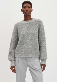 Maglione grigio con texture, colletto tondo e maniche lunghe. Il maglione presenta polsini e orlo a coste, abbinato a pantaloni grigi chiari.