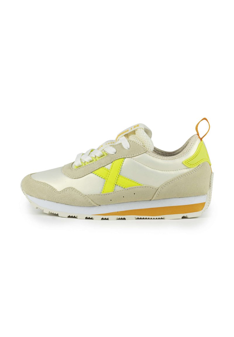 Baskets en suède beige clair et matière brillante. Présentent un accent et un logo jaune vif, des lacets blancs et une semelle en caoutchouc beige.