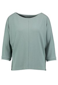 Ljusgrön, texturerad topp med en bred rund halsringning, trekvartsärmar och en avslappnad passform. Tyget har ett subtilt geometriskt mönster.