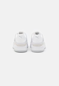 Białe i jasnoszare buty sportowe z fakturowanymi tylnymi panelami i dużym logo. Wyposażone w gładki materiał i solidne gumowe podeszwy.