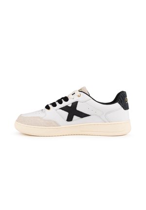 Sneaker bianca low-top con lacci neri e dettaglio a X laterale, punta beige e suola crema su sfondo bianco semplice.