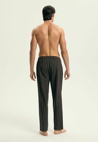 Czarne piżamowe spodnie w kratkę z elastycznym paskiem, z siatkowym wzorem, lekkim materiałem i prostym krojem nogawek.