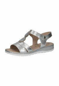 Stříbrné kovové sandály s otevřeným designem, které mají dva kulaté ozdoby, nastavitelné zapínání a texturovanou, polstrovanou stélku na bílé podrážce.