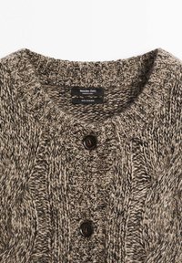 Cardigan in cashmere beige con scollo rotondo a coste, motivo a trecce e due bottoni marrone scuro sul davanti.