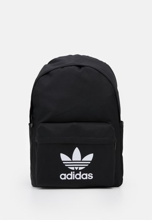 Czarny plecak Adidas z przednią kieszenią na zamek, z białym logo koniczyny i nazwą marki na jednolitym jasnym tle.