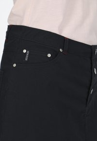 Pantaloni corti neri in tessuto con design classico, dettagli in metallo argentato, tasca frontale e accenti di cucitura rossa.