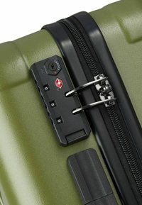 Valigia rigida verde con zip nera e lucchetto a combinazione integrato approvato TSA che blocca i cursori in metallo.