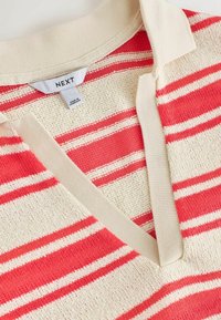 Polo en maille à manches courtes avec rayures horizontales rouges et crème et un col crème, avec une étiquette de marque "NEXT".