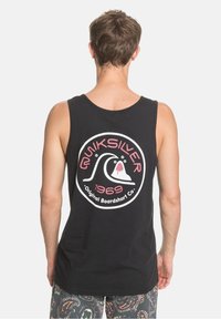 Canottiera nera con un grande logo rotondo che presenta un grafico di un'onda e la scritta "Quiksilver 1969 Original Boardshort Co." in colori contrastanti.