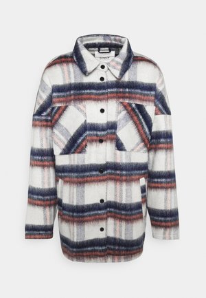 Ruudullinen takki valkoisena, harmaana ja merivärisenä punaisilla yksityiskohdilla. Varustettu napituksella edessä, kahdella rintataskulla ja pitkähihaisilla hihoilla. Pehmeä, tekstuurinen kangas.