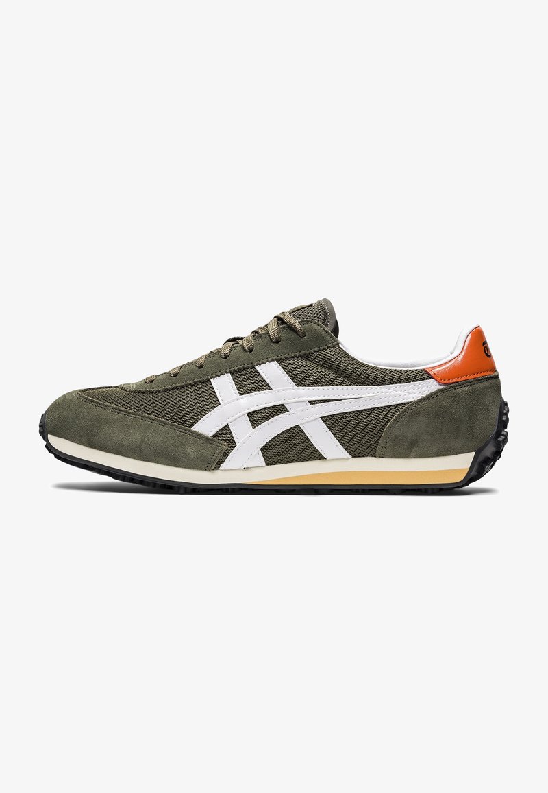 Chaussure de sport avec tige en tissu vert olive et daim, accents blancs, détail orange au talon, et une semelle extérieure en caoutchouc noir. Design classique.