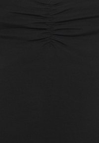Black fitted top made of smooth fabric featuring gathered detailing at the center, creating a textured appearance along the torso.