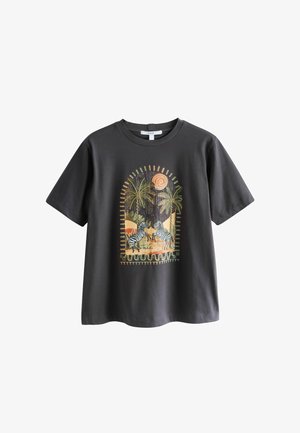 Dunkelgraues T-Shirt mit kurzen Ärmeln und einem Motiv von zwei Zebras unter Palmen und einer orangefarbenen Sonne in einer stilisierten Wüstenlandschaft.