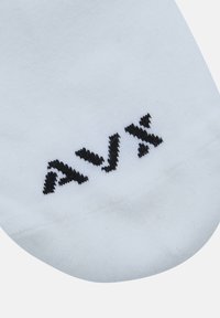 Calze bianche con una texture liscia e logo "AVX" ricamato in nero. Il design presenta una forma a taglio basso, adatta per un abbigliamento casual.