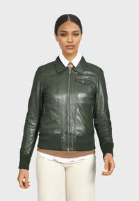 Giacca bomber in pelle verde con zip frontale, polsini e vita a costine, dotata di una tasca sul petto e due tasche laterali con zip.