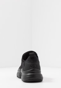 Baskets noires en mesh avec un col rembourré et une semelle en caoutchouc texturé. Marquage au dos. Finition lisse mate.