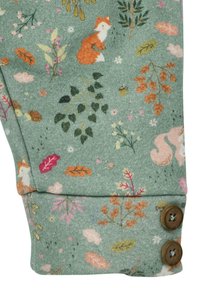 Grüner Stoff mit verstreuten Blumen- und Waldtiermustern, einschließlich eines Fuchses, mit zwei braunen Knöpfen am Ärmel.